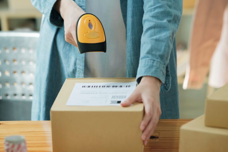 Scanning,Barcode,On,Shipping,Label,With,Handheld,Scanner.,Order,Processing