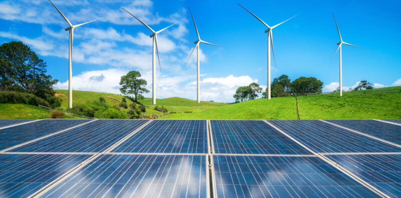 Solar,Panel,And,Wind,Turbines,Farm,On,A,Green,Grass